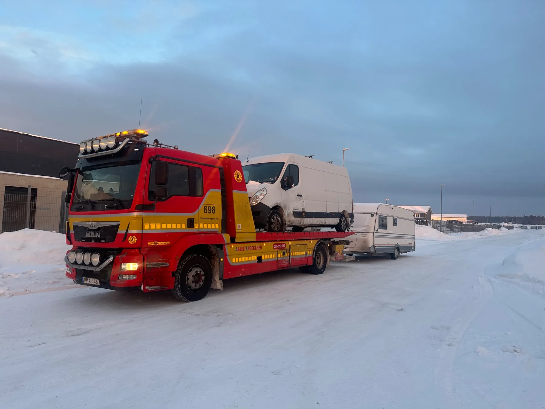 Flakbärgare med transportbil och husvagn